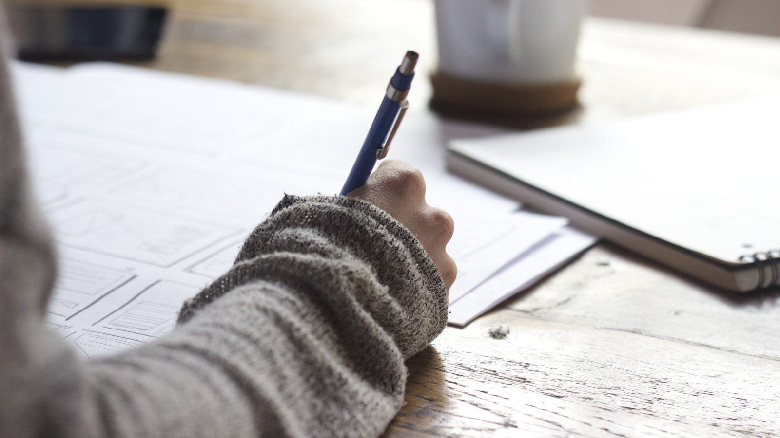 Student som tar notater ved et skrivebord.